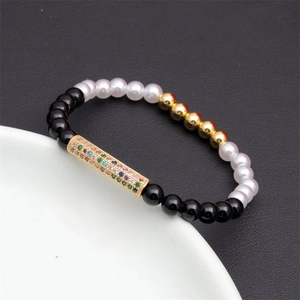 Macro detail of beaded bracelet with rainbow zircon metal bar and mixed natural stones