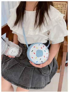 Detail of a light blue donut-style girls' crossbody bag featuring a Hello print