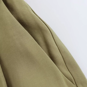 Close-up of olive green twill fabric texture and professional stitching on casual shorts