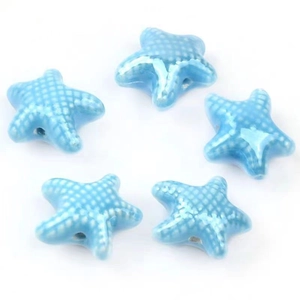Close-up of blue glazed starfish ceramic beads with white polka dots for DIY jewelry