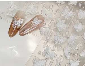Détail de stickers nail art papillon 3D blancs avec texture gaufrée et accents perlés