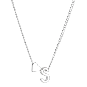 Détail des pendentifs cœur argenté et lettre S sur une chaîne en métal poli