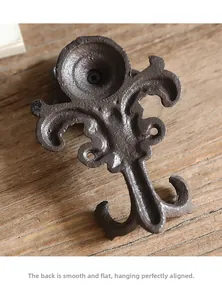 Makroansicht der flachen Rückseite eines gusseisernen Fleur-de-Lis-Hakens mit Befestigungslöchern