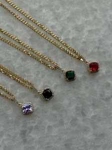 Detail of 18k gold plated necklaces with colorful zircon heart and square pendants