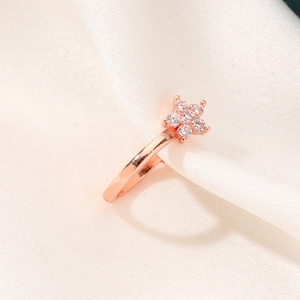 Elegant rose gold star flower ring with clear crystals on white silk background