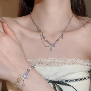 Detail of butterfly heart necklace with colorful gravel stones on model neck