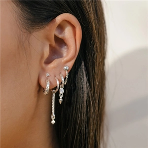 Close-up of 925 sterling silver C-shape hoop earrings and zircon stud set on model