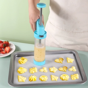 Manual cookie press machine with blue plastic housing squeezing dough onto a baking sheet