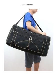 Close-up of large black Oxford cloth travel bag with gold trim and multiple pockets