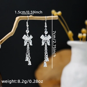 Detail showing dimensions of silver bow tassel earrings with small bells hanging on a branch