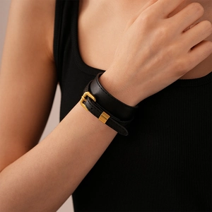 Detail of vintage double-wrap faux leather bracelet with polished gold-tone buckle
