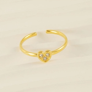 Macro shot of gold heart ring featuring three sparkling zircons on an open band