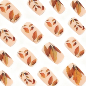 Fall themed press-on nails set featuring elegant beige finish and warm leaf patterns