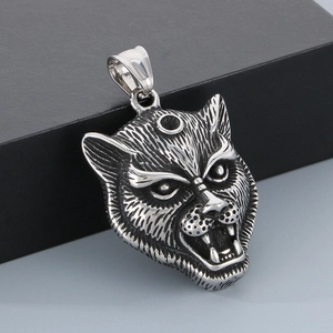 Macro shot of silver wolf head pendant showing detailed metal texture and sharp fangs
