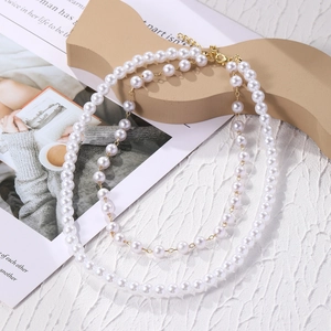 Detail of layered baroque pearl necklace with gold clasp on an elegant background