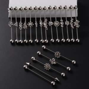 Macro view of silver industrial barbell earrings with various crystal flower designs