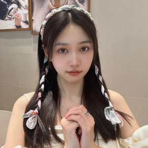 Floral print headband with pearls and chiffon ribbon worn by a model in a cozy setting