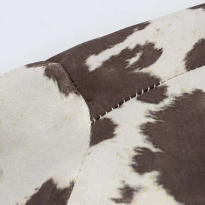 Gros plan sur un tissu en velours à imprimé vache avec des détails de couture précis