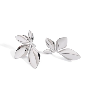 Detailed view of silver leaf-shaped earrings in polished stainless steel on white backdrop