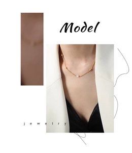 Detail of 18k gold chain necklace with a centered freshwater pearl on model's neck