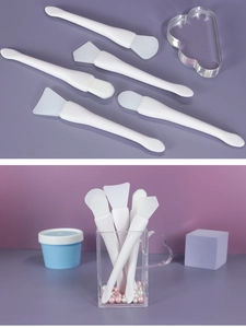Detailed view of 5-piece white silicone facial mask brushes in an acrylic storage cup