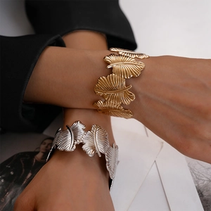 Detail of gold and silver leaf-shaped cuff bracelets with delicate vein texture