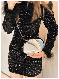 Close-up of silver mirror metal clutch bag with chain paired with black sequin feather dress