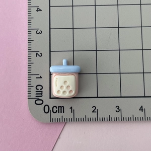 Close-up of a 1.5cm mini resin bubble tea cup charm being measured on a ruler