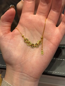 Gros plan d'un collier en plaqué or avec un pendentif pièce et gravure chinoise