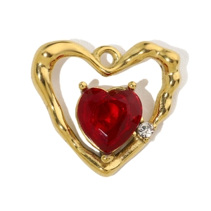 Detailed close-up of a gold heart pendant with a red stone and clear zircon accent