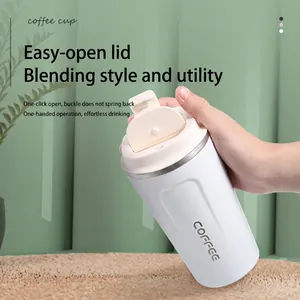 White stainless steel vacuum insulated coffee mug with flip-top lid held in hand