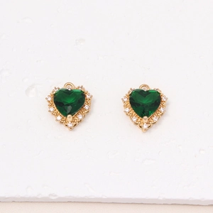 Macro detail of two heart-shaped green zircon pendants with gold-plated micro-pave setting