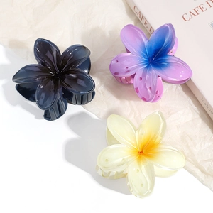 Detailed close-up of three Y2K hibiscus flower hair claws in blue and cream colors