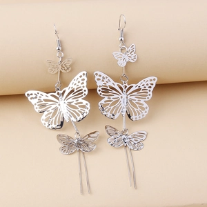 Detail of silver long hollow butterfly drop earrings with a metallic finish and hook style
