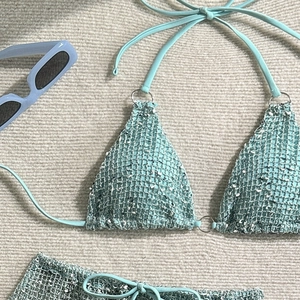 Detailed view of light blue tweed bikini with halter triangle cups and metal ring accents