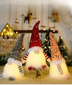 Close-up of lighted Christmas gnomes with sequin hats and glowing LED plush beards