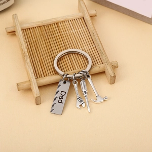Detailed shot of stainless steel Dad keychain with miniature hammer and wrench tools