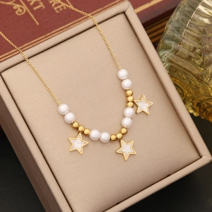 Star shell necklace with gold chain and pearls presented in a chic jewelry box