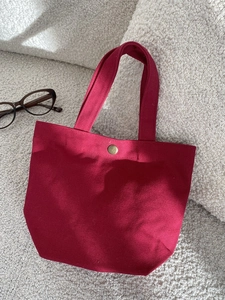 Minimalist burgundy canvas tote bag with gold snap button closure for daily commuting