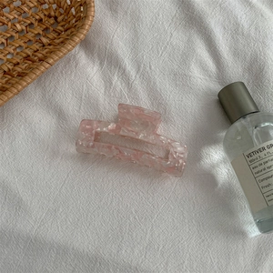 Detail of pink marble pattern acetate hair claw clip with square hollow design