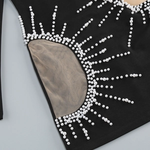 Détail de la broderie de perles en soleil sur robe noire avec mesh ajouré