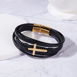 Detailed macro view of triple-layer braided black leather bracelet with golden cross charm