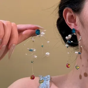 Detail of long tassel earrings with blue square crystal and multicolored glass beads