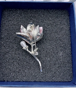 Macro detail of magnolia flower brooch back with silver plating and secure safety pin clasp