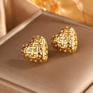 Detailed macro shot of vintage gold heart earrings with woven texture and white rhinestones