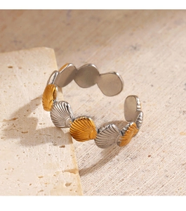 Detailed macro view of two-tone 18K gold plated shell ring on a textured stone surface