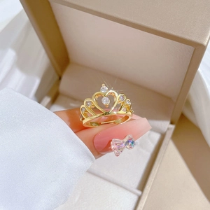 Elegant gold crown heart ring with sparkling zircons worn on finger in jewelry box