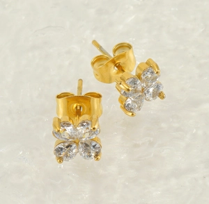 Gros plan sur les boucles d'oreilles trèfle en acier inoxydable doré et oxydes de zirconium