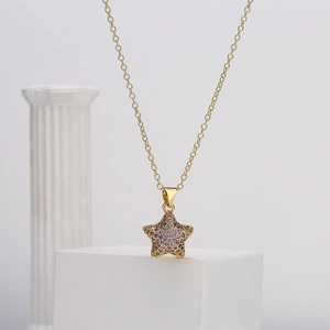 18K gold plated star pendant necklace with purple zircons on a white display stand