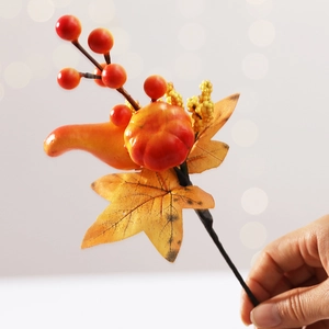 Artificial Halloween bouquet with orange pumpkins, berries and autumn maple leaves